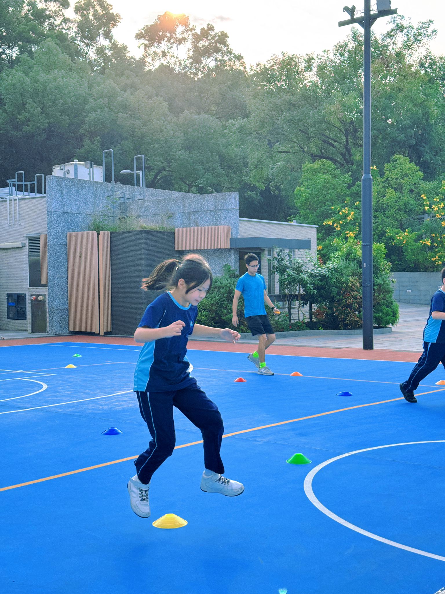 A group of children playing basketball on a blue court.
