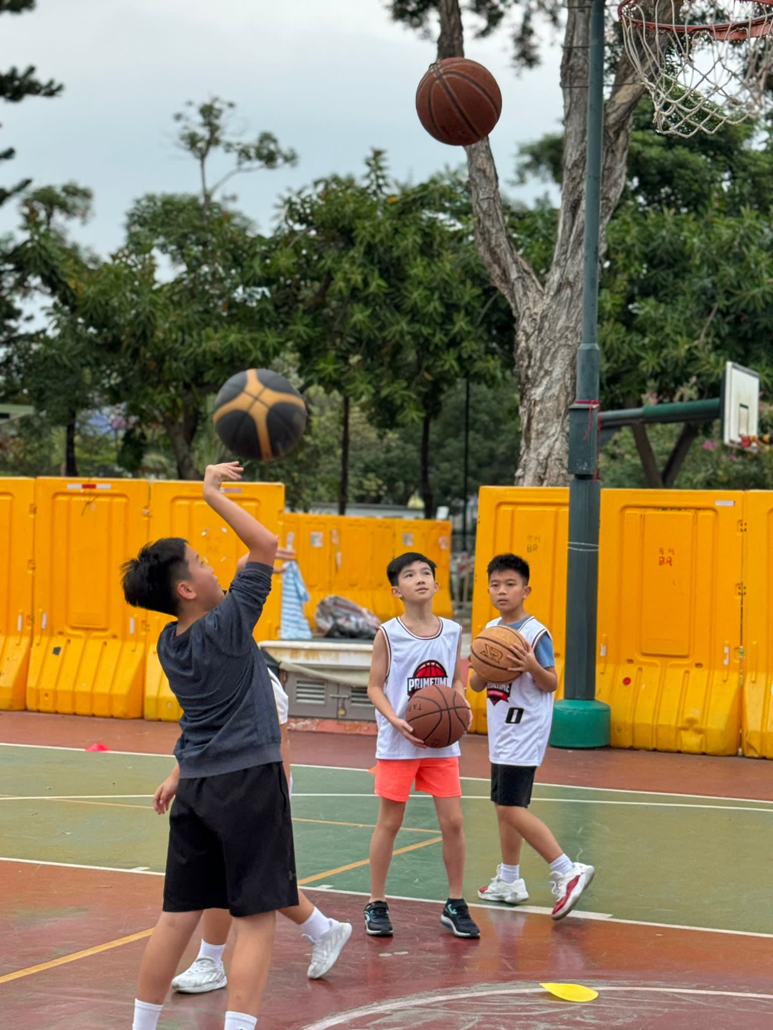 A group of children playing basketball on a court.